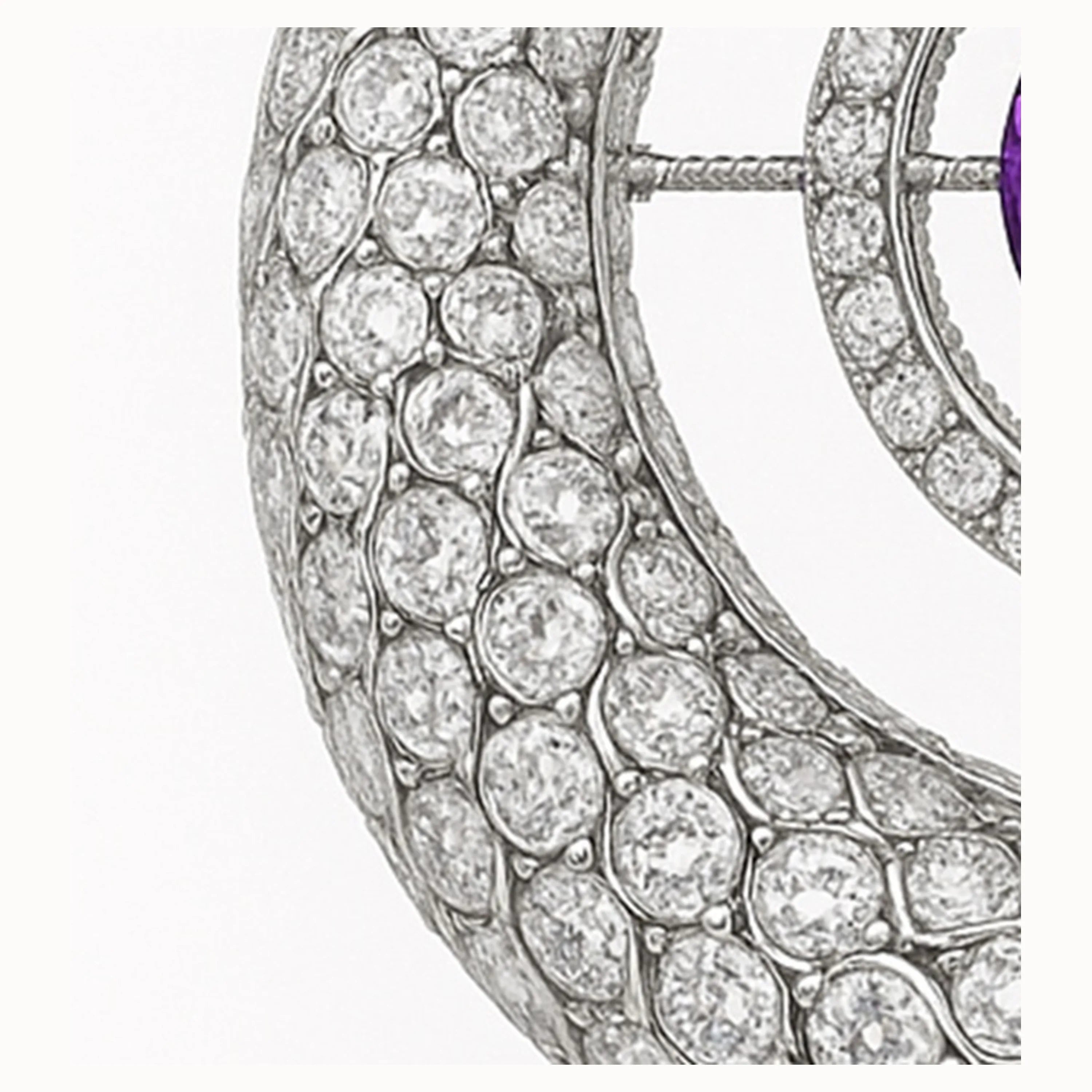 Macro of diamond-pavé serpent scales on a white-gold ouroboros pendant.