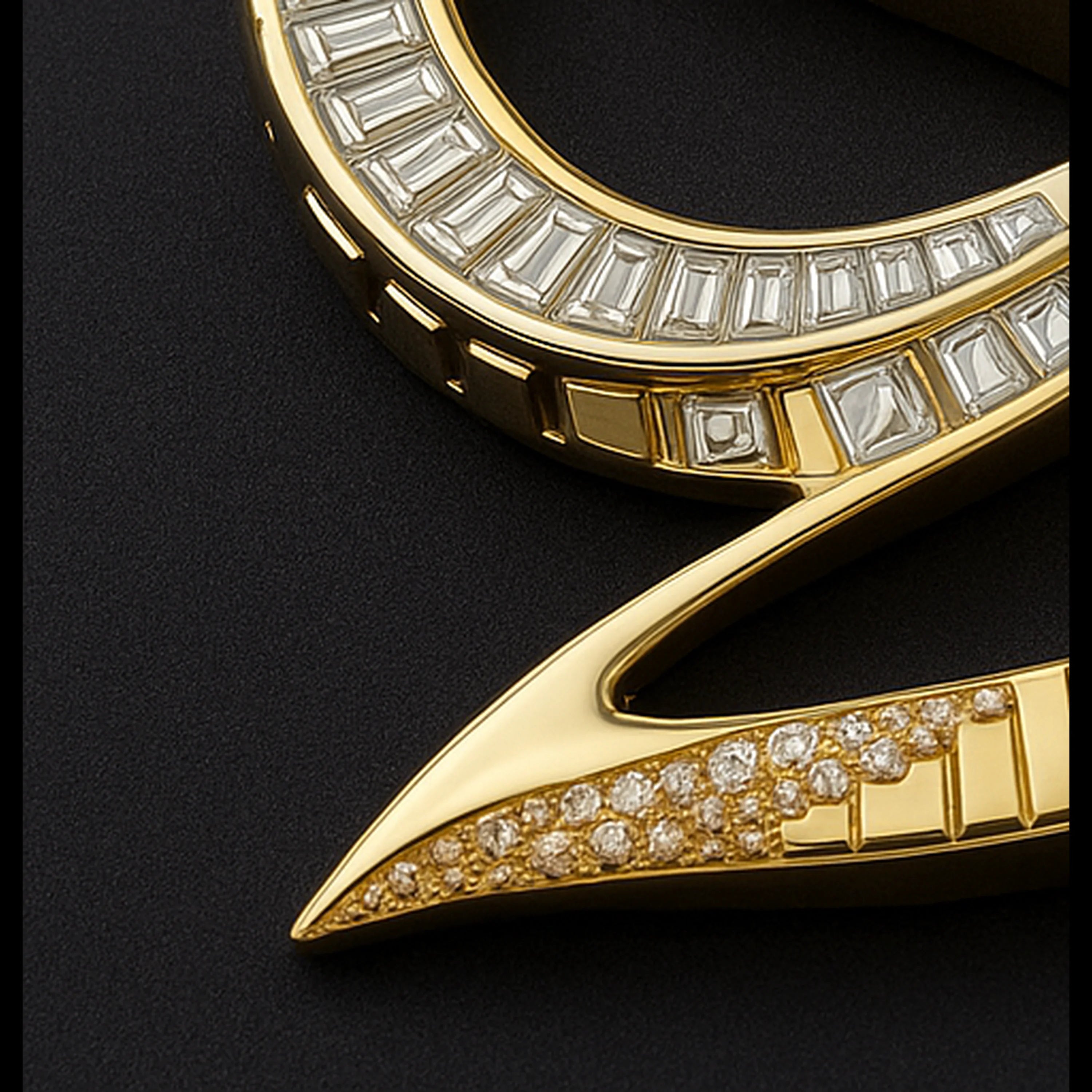 Close-up of a Redbutan Sigil Velocity Monogram High Jewel Pendant original design race track inspired yellow-gold sculptural pendant segment with stepped baguette diamonds in a channel setting and a pavé-set diamond point, photographed on a dark matte surface.