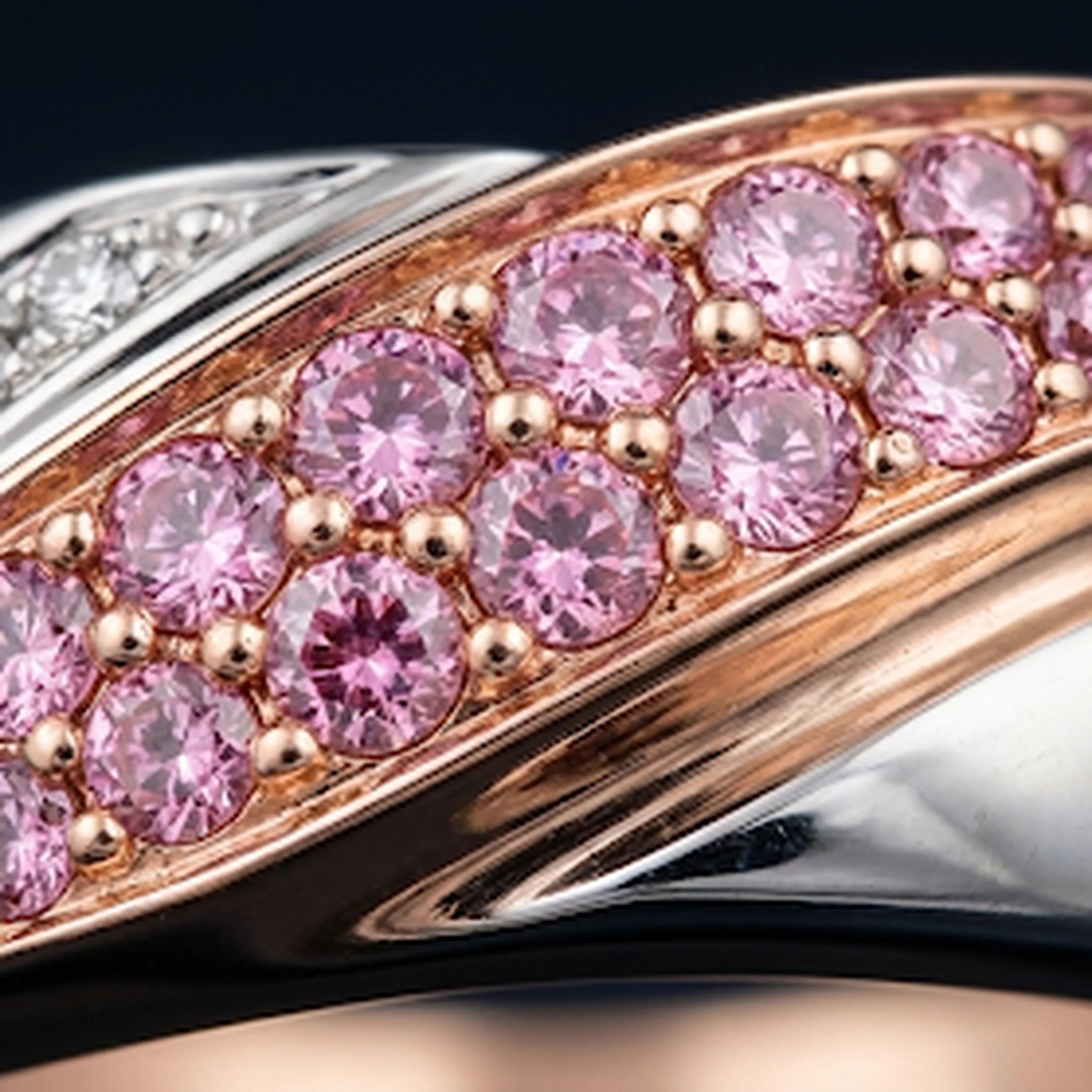 Macro of Redbutan Aeroyacht Hydroline Ring with pink pavé stones on a two-tone gold band and mirror-polished contours.